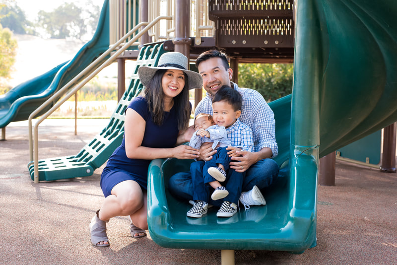 outdoor family portrait photo with newborn on playground