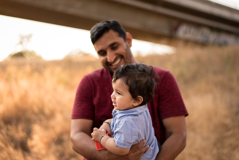 candid outdoor dad and baby family portrait photo at Putah Creek in Davis